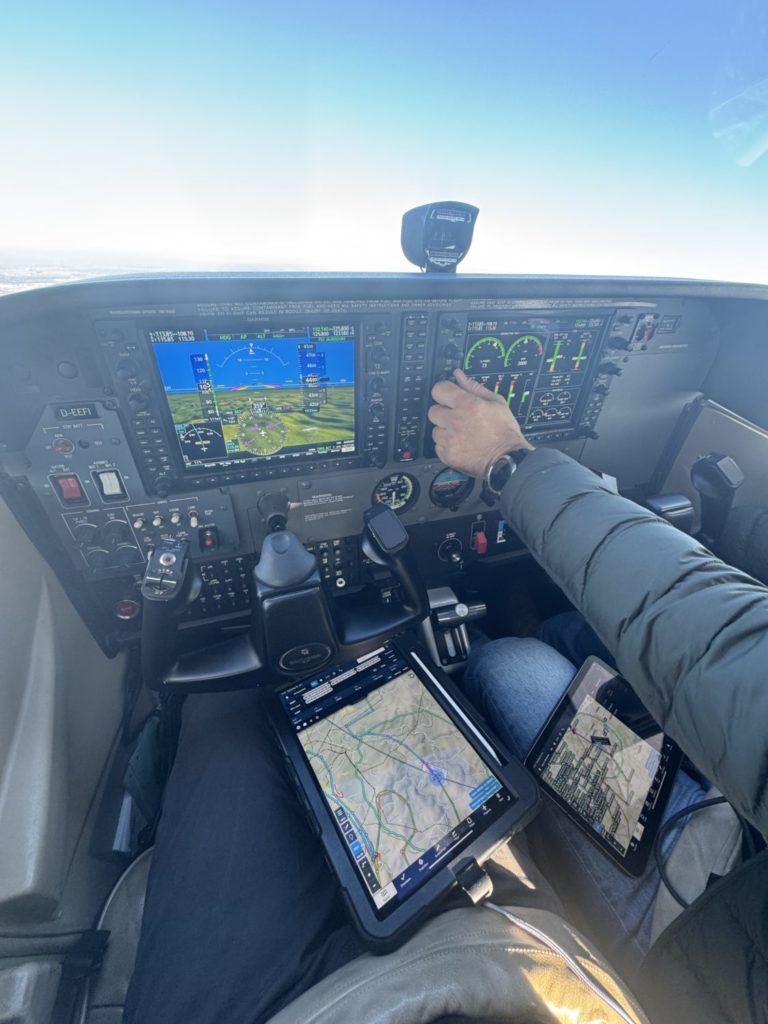 Das Cockpit der Cessna 172 während des Kunstfluges, auf den Knien das Tablet mit dem Motiv.